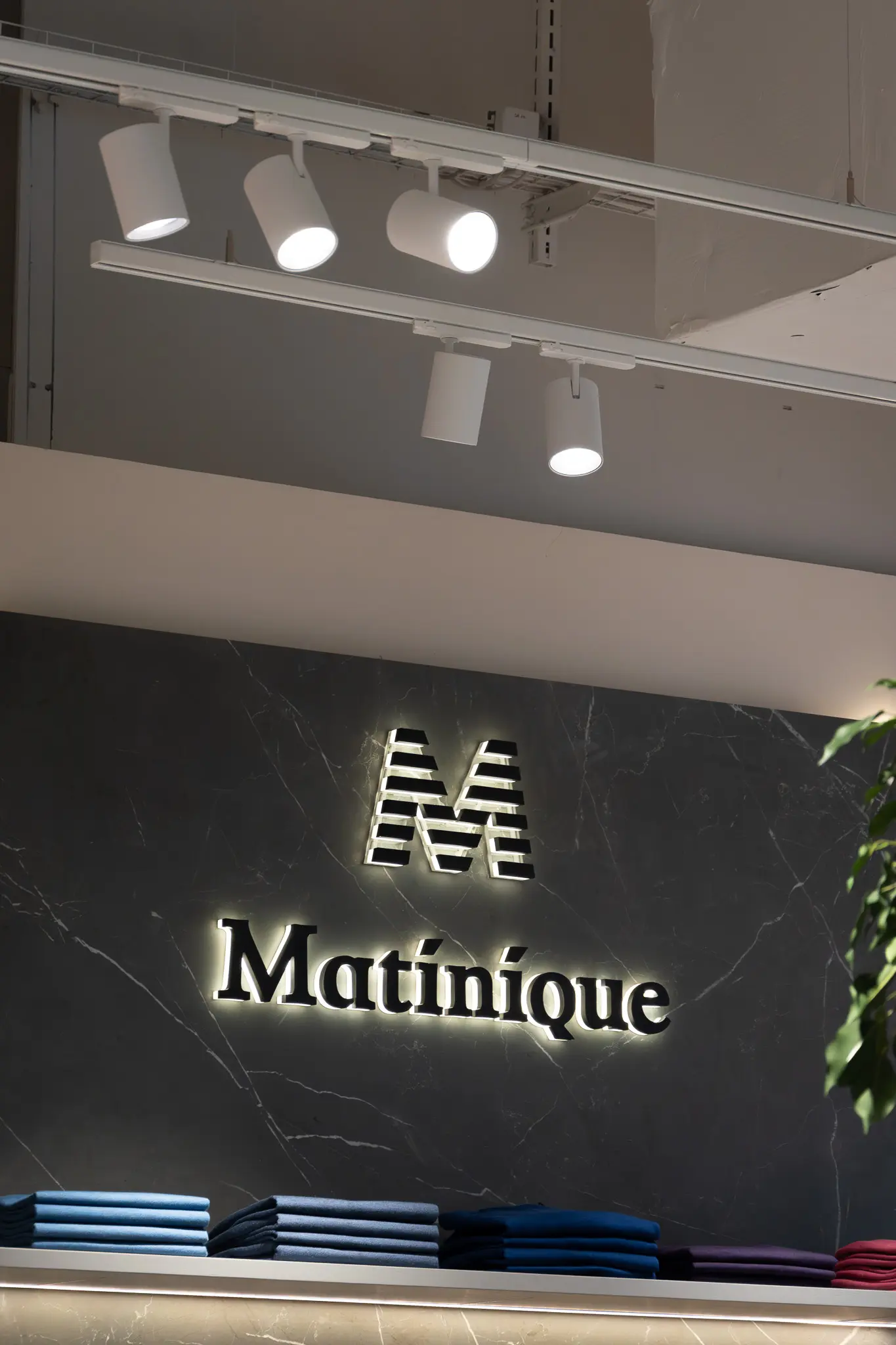 Illuminated logo on a dark wall